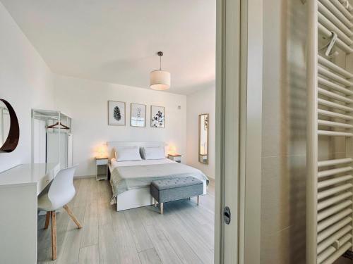 a bedroom with a bed and a desk and a chair at Villa Noga Rooms in Selargius