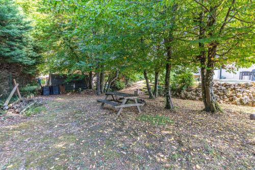 a wooden picnic table in a park with trees at Villa Saint-Martin - Pompignac in Pompignac