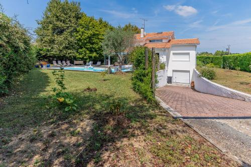 a backyard with a house and a swimming pool at Villa Saint-Martin - Pompignac in Pompignac