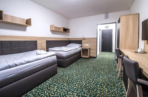 a hotel room with two beds and a desk at Rehabilitační sanatorium - Lázně Darkov in Mizerov