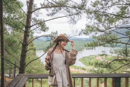 a woman wearing a hat on top of a fence at Lavender Dalat Hotel and Resorts in Da Lat