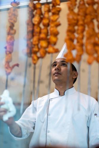 a man wearing a chefs hat on his head at Pyramid Continental Hotel in Juba
