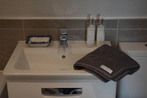 La salle de bains est pourvue d'un lavabo et d'une serviette. dans l'établissement Luxury Barn near Soho Farmhouse, à Middle Barton