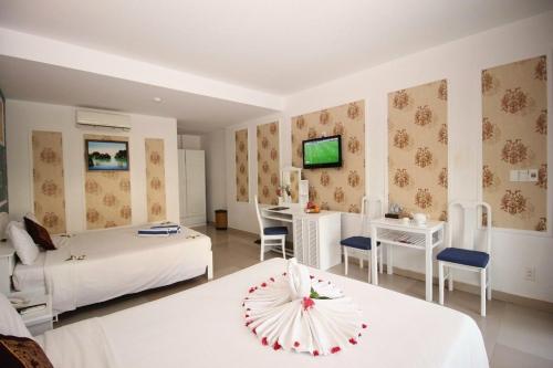 una camera d'albergo con due letti e un tavolo con un ombrello di MUINE SUN AND SEA RESORT & GLAMPING a Mui Ne