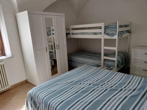 1 dormitorio con 2 literas y espejo en appartamento in Borgo storico., en Pontremoli