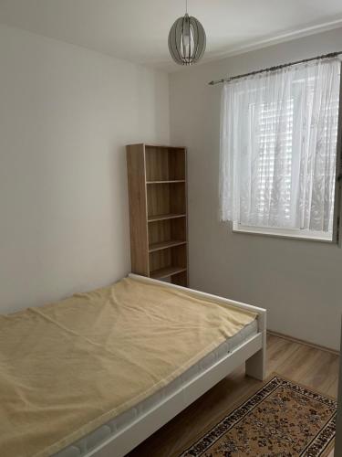 een slaapkamer met een bed, een raam en een plank bij Apartments Đurđa, Sabunike in Privlaka
