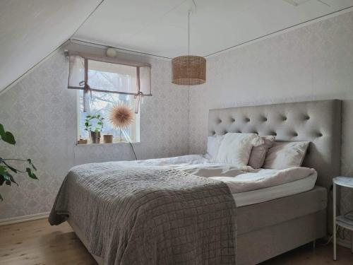 1 dormitorio con cama, ventana y ventana en Hus i lugnt område, 15 min från Örebro en Vintrosa