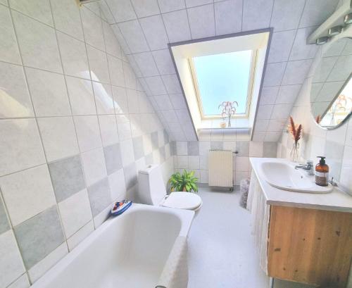 y baño con bañera, aseo y lavamanos. en Hus i lugnt område, 15 min från Örebro en Vintrosa