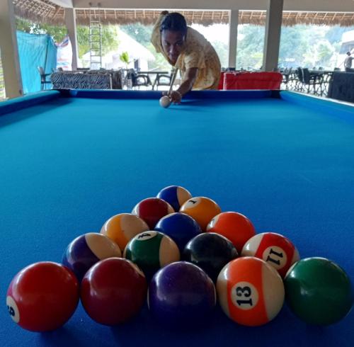 a man playing a game of pool on a pool table at MAISON CARREE in Andilana