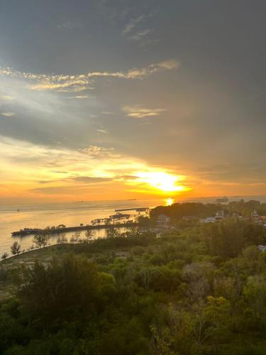 a sunset over the water with a city and the ocean at D'Wharf Hotel & Serviced Residence in Port Dickson