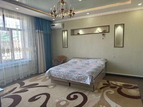 a bedroom with a bed and a chandelier at Kurak Homestay in Bishkek