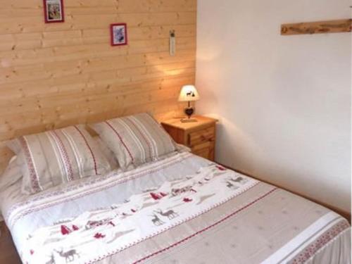 Ce lit se trouve dans une chambre dotée d'un mur en bois. dans l'établissement Bel appartement 2 pièces, skis aux pieds, pour 6 pers. - FR-1-322-356, aux Orres
