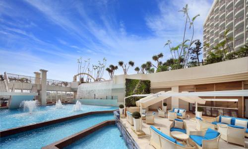 a resort with a swimming pool and a hotel at Loisir Hotel Naha in Naha