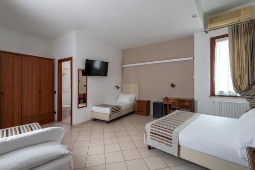 a hotel room with two beds and a television at Hotel Mantegna Stazione, MantegnaHotels in Mantova