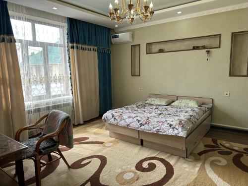 a bedroom with a bed and a table and a chair at Kurak Homestay in Bishkek