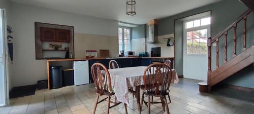 una cucina con tavolo e sedie in una stanza di Loge de la Saire a Gonneville