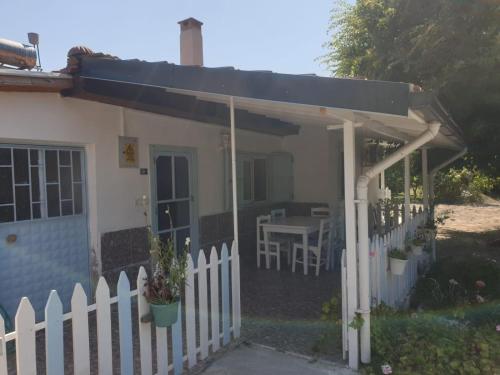 a small white house with a fence and a table at Mert Village house in Ortaca