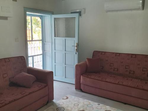 a living room with two couches and a door at Mert Village house in Ortaca
