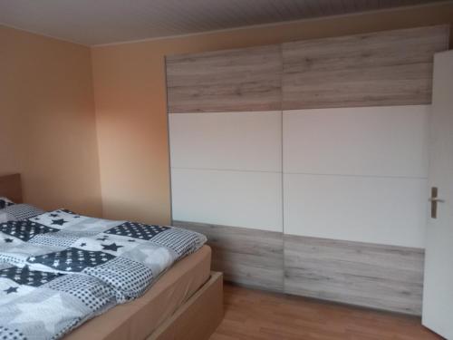 a bedroom with a bed and a white cabinet at Ferienwohnung 1 Bartölke in Bockenem