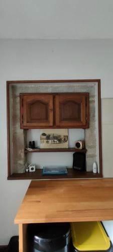 Elle comprend un bureau en bois avec des placards en bois. dans l'établissement Loge de la Saire, à Gonneville