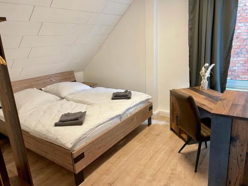 a bedroom with a bed and a desk and a table at FLATLIGHT - Stylish apartment - Kitchen - Parking - Netflix in Hildesheim