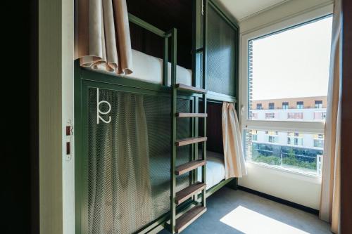 a room with a green book shelf and a window at JOST Auberge de Jeunesse Montpellier Centre St Roch in Montpellier