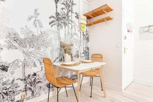 une salle à manger avec une table, des chaises et un papier peint tropical dans l'établissement Appartement proche Montparnasse - Jungle - II, à Paris