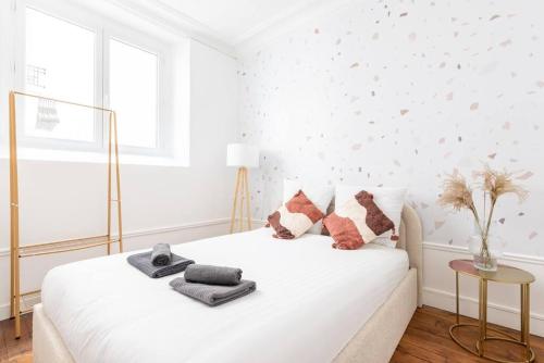 - une chambre blanche avec un lit et des oreillers dans l'établissement Appartement proche Montparnasse - Jungle - II, à Paris