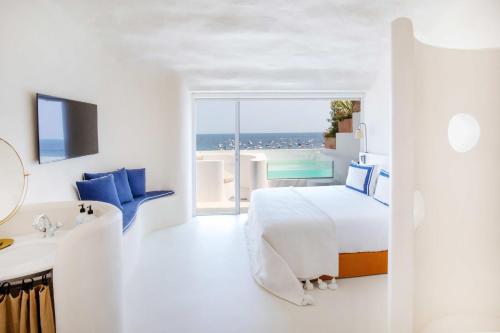 ein weißes Hotelzimmer mit einem Bett und einem Bad in der Unterkunft Hotel Isabella's Llafranc in Llafranc