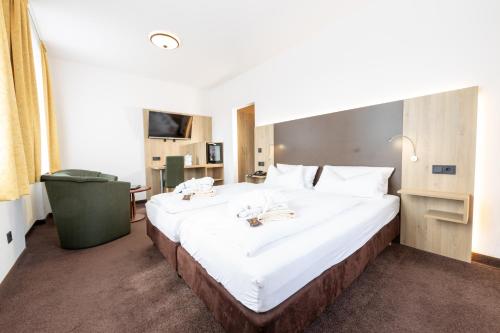 a large white bed in a hotel room at Sonnenhotel Hoher Hahn in Schwarzenberg