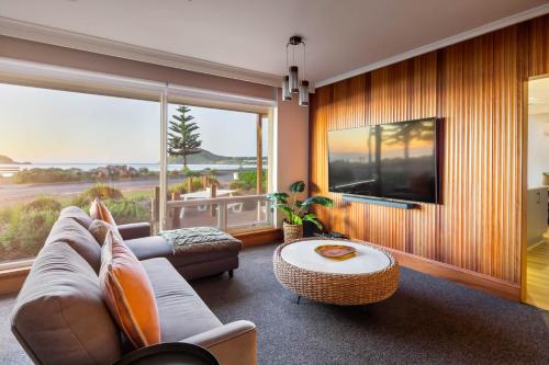 a living room with a couch and a table at Frankies Beach House - A Breezy Esplanade Escape in Encounter Bay