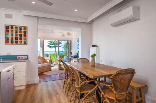 a kitchen and dining room with a wooden table and chairs at Frankies Beach House - A Breezy Esplanade Escape in Encounter Bay