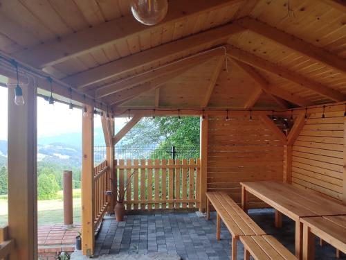 a wooden pavilion with a wooden table and benches at OSADA WASYLÓWKA in Laskowa
