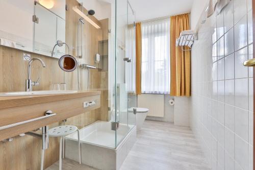 シュヴァルツェンベルクにあるSonnenhotel Hoher Hahnのバスルーム(シャワー、洗面台、トイレ付)