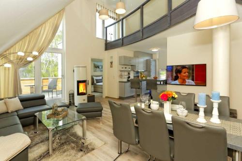 a living room with a dining table and a fireplace at Kapitaensweg 2 Kajuete 07 in Ostseebad Karlshagen