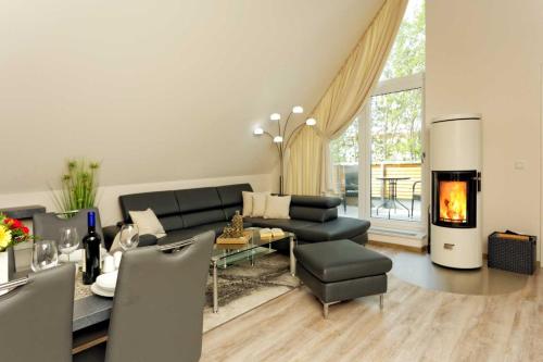 a living room with a couch and a fireplace at Kapitaensweg 2 Kajuete 07 in Ostseebad Karlshagen