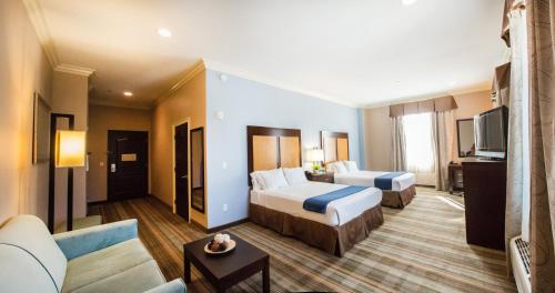 a hotel room with two beds and a couch at Holiday Inn Express Benicia by IHG in Benicia