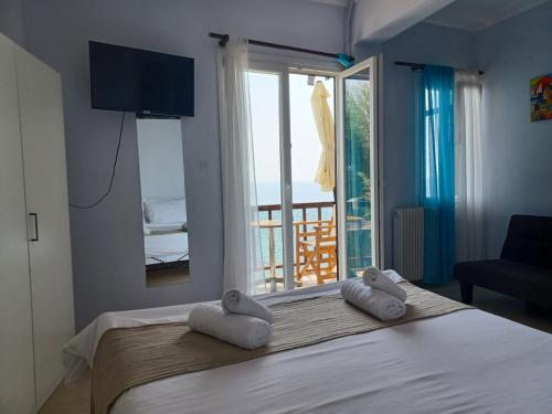 1 dormitorio con 1 cama con 2 toallas en Als Plomari - Sea View Apartment, en Plomari