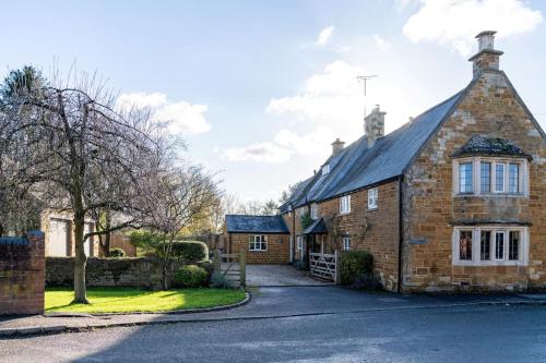 an old brick house with a driveway at Countryside 6-bedroom cottage in Great Easton
