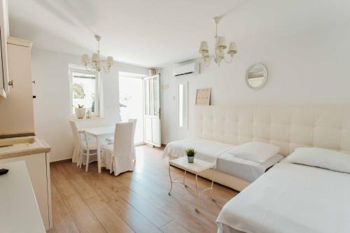 una camera bianca con letto e tavolo di Villa Bella with pool a Novalja (Novaglia)