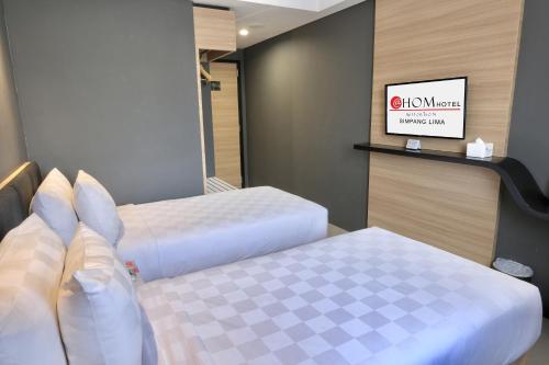 Habitación de hotel con 2 camas y espejo en @Hom Semarang Simpang Lima en Semarang