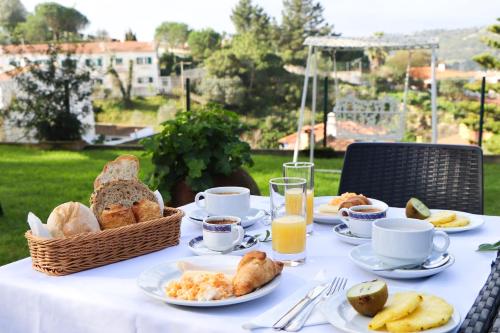 un tavolo con colazione a base di pane e succo d'arancia di Hotel Louro a Óbidos