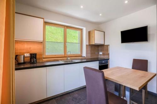 a kitchen with a wooden table and a television at Bachwiesl Hof Apt Pichl in Proves