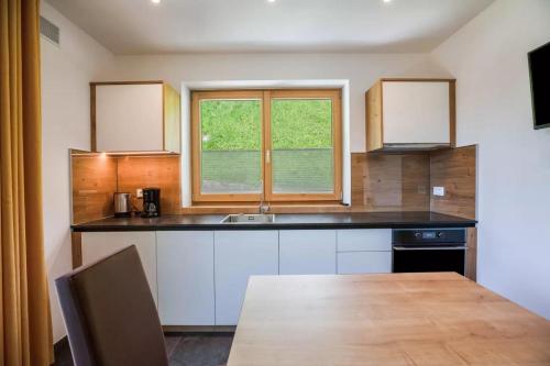 a kitchen with a table and a sink and a window at Bachwiesl Hof Apt Pichl in Proves