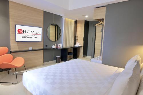 Habitación de hotel con cama y espejo en @Hom Semarang Simpang Lima en Semarang
