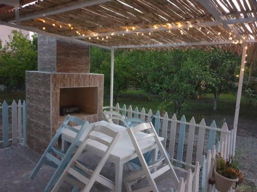 a patio with a table and chairs and a fireplace at Mert Village house in Ortaca