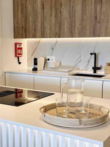 a kitchen with a glass pitcher on a tray on a counter at Front Sea Apartment Albufeira in Albufeira