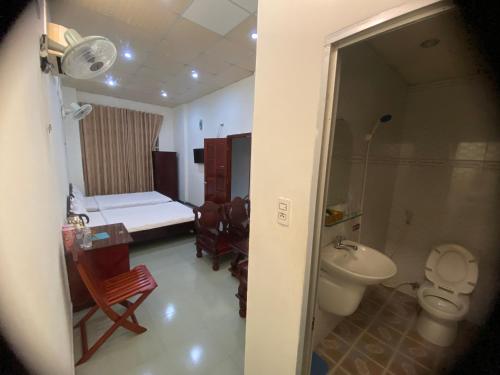 un bagno con servizi igienici e una camera con letto di Hotel Cát Tường a La Gi