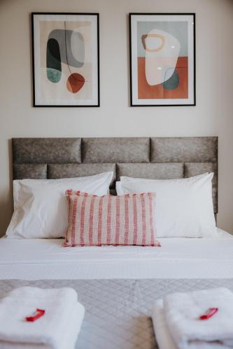 a bedroom with a white bed with two pillows at Pearl Apartel in Volos