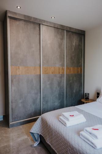 a bedroom with a bed with two towels on it at Pearl Apartel in Volos